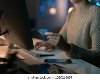 Woman Connecting With Her Computer Late At Night And Doing Online Shopping, She Is Entering Credit Card Information, Hands Close Up