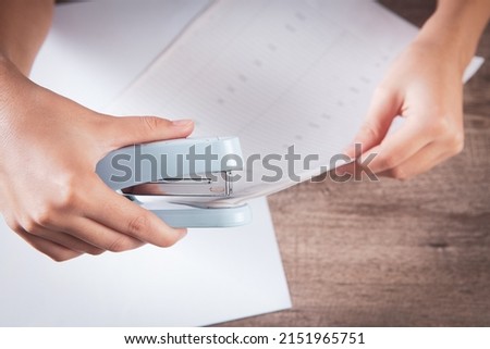 woman connects papers with a stapler