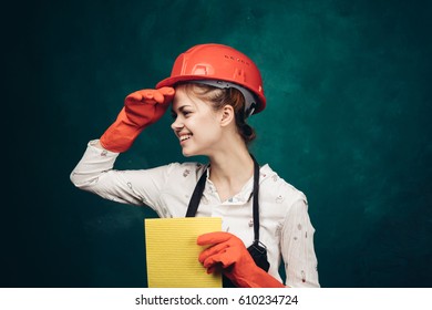 A woman in a construction helmet looks into the distance