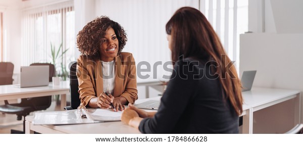 Woman consulting with a female financial manager at\
the bank
