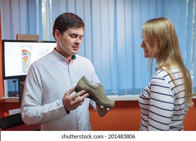 Woman Consulting Foot Doctor In His Clinic