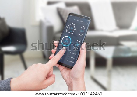 Woman control light in living room interior with smart home control app on modern mobile devices. Living room interior in background.