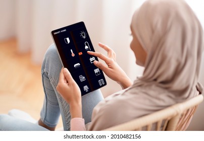 Woman Controlling Smart Home Devices Using Digital Tablet With Launched App In Living Room. Smart Home Concept. Young Arab Woman In Hijab Presses On Buttons On Touch Screen Indoors Interior, Collage