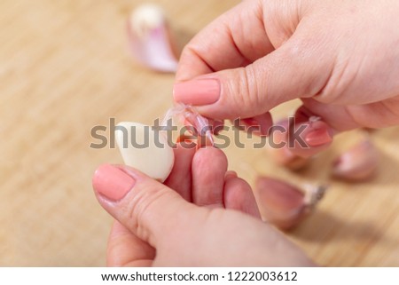 woman cook cleans garlic cloves, hands closeup