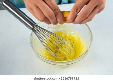 Woman cook homemade mayonnaise add lemon juice in glass bowl to egg mustard mass on kitchen. Preparing mixing sauce for salad, meat dishes. Dressing for different dishes. Culinary, cuisine concept. - Powered by Shutterstock