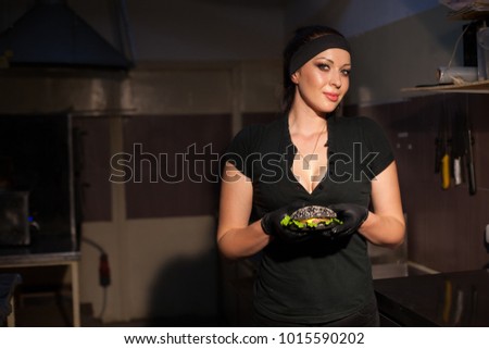 woman Cook prepares a burger in the kitchen