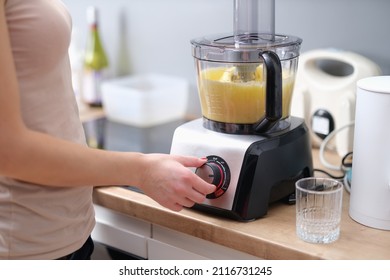 Woman cook turning on button of food processor for kneading dough closeup - Powered by Shutterstock