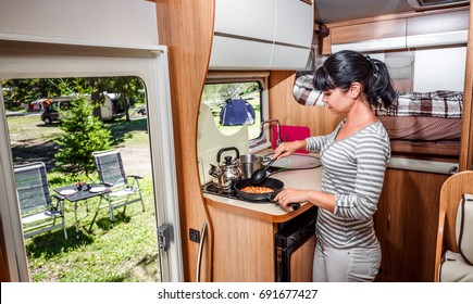 Woman cooking in camper, motorhome interior. Family vacation travel, holiday trip in motorhome, Caravan car Vacation.