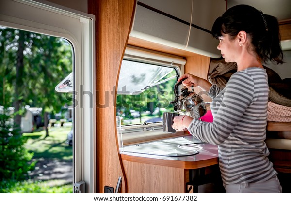 Woman\
cooking in camper, motorhome interior. Family vacation travel,\
holiday trip in motorhome, Caravan car\
Vacation.