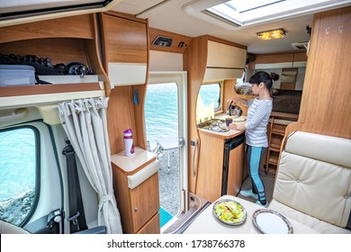 Woman cooking in camper, motorhome RV interior. Family vacation travel, holiday trip in motorhome, Caravan car Vacation.