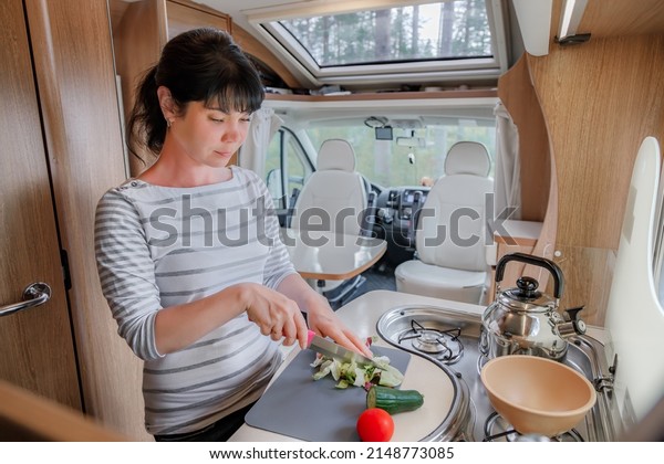 Woman\
cooking in camper, motorhome RV interior. Family vacation travel,\
holiday trip in motorhome, Caravan car\
Vacation.