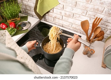 Woman Cooking Delicious Pasta On Electric Stove At Home