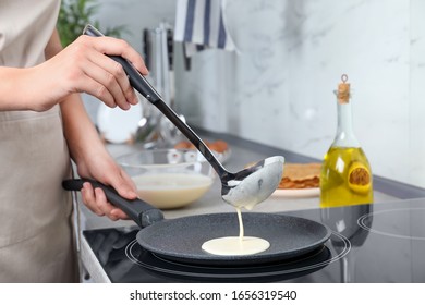 Woman cooking delicious thin pancakes on induction stove, closeup - Powered by Shutterstock