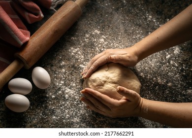 Woman Cooking A Dough In A Dark Kitchen