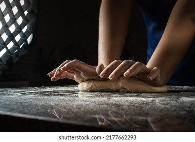 Woman Cooking A Dough In A Dark Kitchen