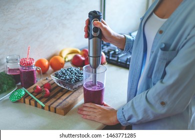 Woman Cooking Fresh Blueberry Smoothie With Hand Blender At Kitchen At Home. Healthy Eating And Berry Drink