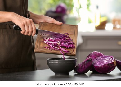 Woman cooking fresh salad with ripe red cabbage at grey table - Powered by Shutterstock