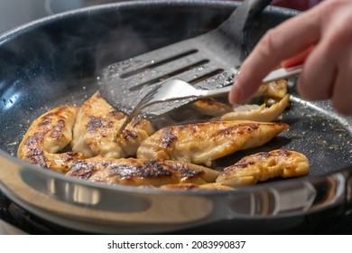 Woman cooking and frying chicken breasts and chicken filet in a pan on an hot stove in the kitchen as delicious meal and diet dinner cuisine for healthy nutrition with smoking hot meat and barbecue - Powered by Shutterstock