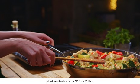 Woman Cooking Frying Meat And Vegetables In Wok Pan On Kitchen Table. Closeup Hands. Real, Authentic Cooking.