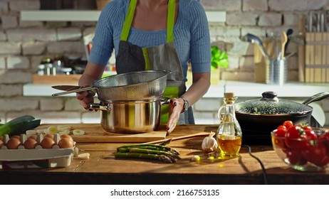 Woman Cooking In Kitchen. Real People, Authentic, No Face.