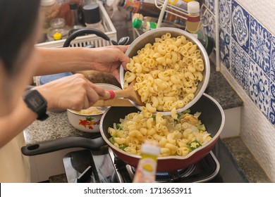 Woman Cooking Macaroni Dish In Flying Pan During Covid-19 Quarantine. Indoor