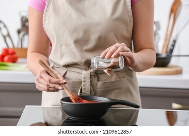 Woman Cooking Organic Tomato Sauce In Frying Pan On Stove In Kitchen