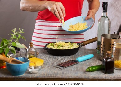 Woman Cooking Pasta With White Cream Sauce At Home In The Kitchen