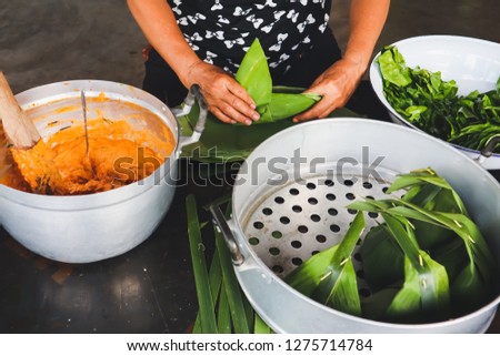Woman cooking and prepared for Thai steamed curry fish.