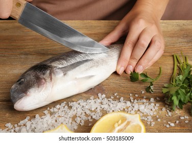 Woman Cooking Raw Fish On Kitchen