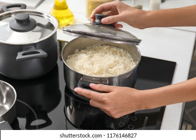 Woman Cooking Rice On Stove In Kitchen