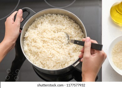 Woman Cooking Rice On Stove In Kitchen