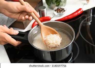 Woman Cooking Rice In Saucepan On Stove, Closeup