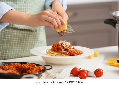 Woman cooking tasty pasta bolognese in kitchen, closeup