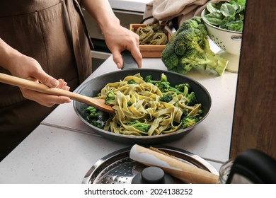 Woman Cooking Tasty Pasta With Vegetables In Kitchen