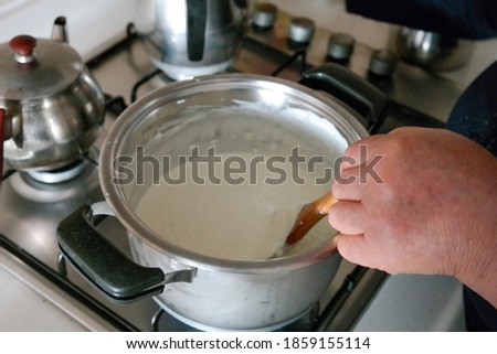 Woman cooking yogurt soup on the stove