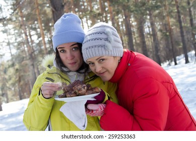 Woman cooks the meat at a picnic