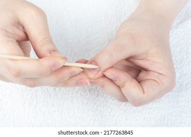 A Woman Corrects The Cuticle On Her Hand With An Orange Stick. Clos Up.