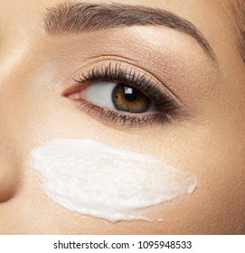 Woman With Cosmetic Cream Smear On Face Near Eye.  Skin Care  Concept. Beauty Treatment Concept.