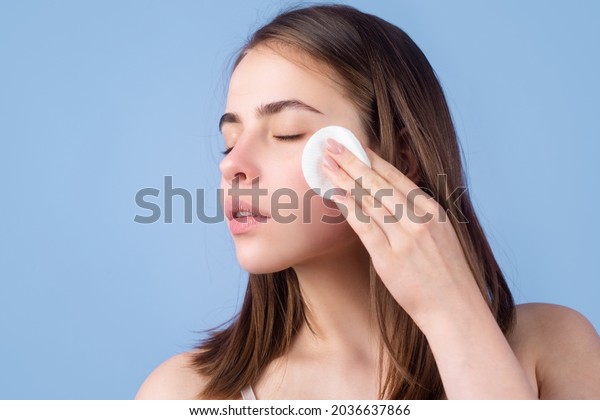 Woman with cotton pads,\
sponge, cotton ball. Skin care and beauty concept. Girl removes\
makeup with cotton ball from face. Skin care concept. Woman using\
cotton pad.