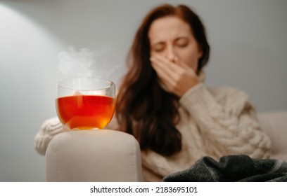 Woman Coughs In Hand With Sore Throat Holding Hot Medicinal Tea. Fever And Seasonal Flu Concept.