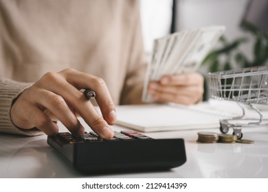 Woman counting and calculate cost money with calculator at home. Budget of disadvantaged and low income family for rising food and grocery store prices and expensive daily consumer goods concept.