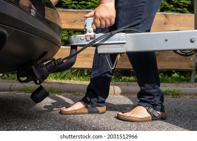 woman couple a trailer (i.s., hooked) into a ball-type tow hitch - Shutterstock ID 2031512966
