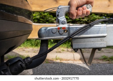 woman couple a trailer (i.s., hooked) into a ball-type tow hitch - Shutterstock ID 2032917770