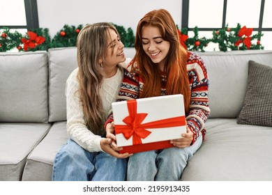 Woman couple unpacking gift sitting by christmas decor at home - Powered by Shutterstock