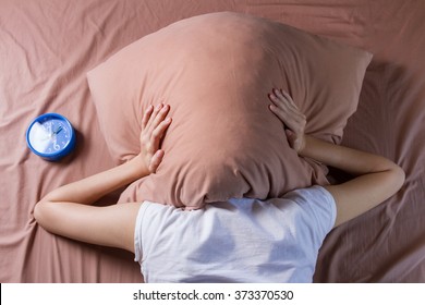 woman cover her head with pillow, sleeping problem concept - Powered by Shutterstock