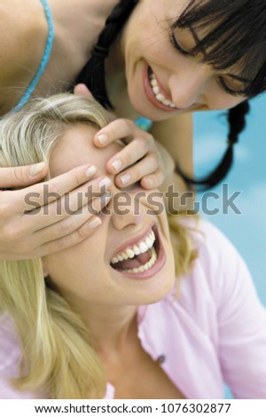 Woman covering anothers eyes