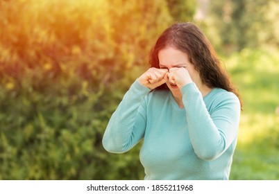 Woman covering eyes by hand of bright sunlight