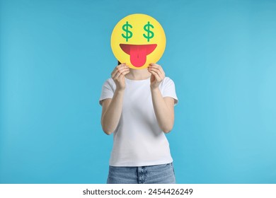 Woman covering face with dollar signs instead of eyes on light blue background - Powered by Shutterstock