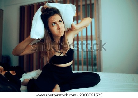 
Woman Covering her Ears Trying to Protect Herself from Upstairs Noise. Unhappy person wanting to get some rest annoyed by loud music
