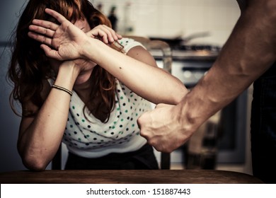 Woman covering her face in fear of domestic violence - Shutterstock ID 151887443